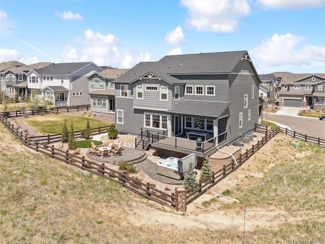 rear view of house with a residential view, a fire pit, and a fenced backyard