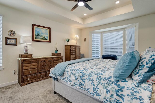 bedroom featuring a tray ceiling, ceiling fan, and light colored carpet