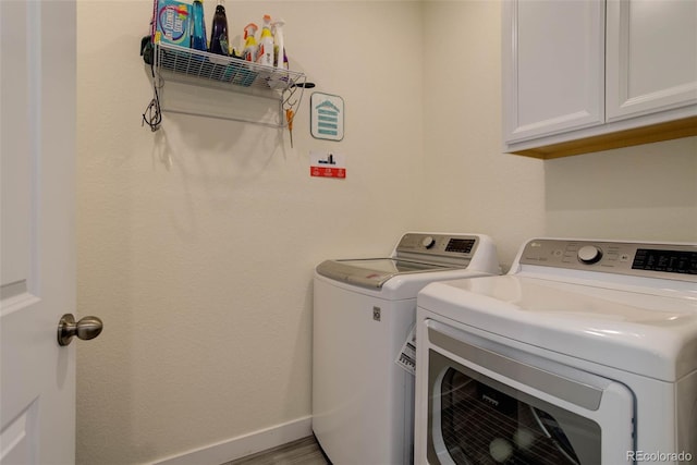 washroom featuring cabinets and separate washer and dryer