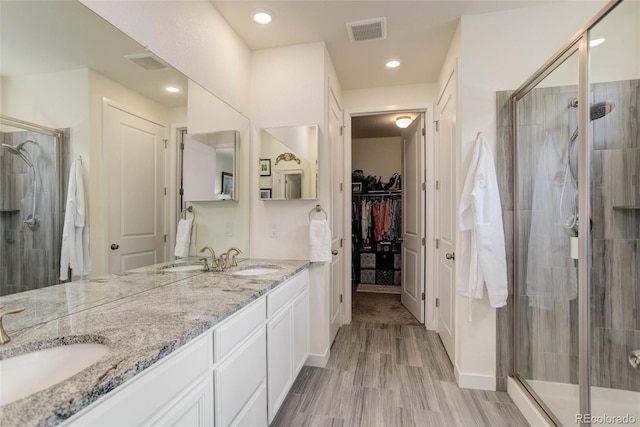 bathroom with a shower with door and vanity