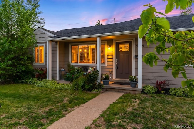 5125 Umatilla St, Denver, CO 80221 - exterior entry at dusk with a yard and covered porch
