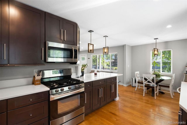 5125 Umatilla St, Denver, CO 80221 - kitchen featuring appliances with stainless steel finishes, light countertops, recessed lighting, dark brown cabinetry, and light wood finished floors