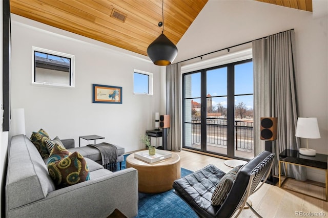 living room featuring vaulted ceiling, light hardwood / wood-style flooring, and wooden ceiling