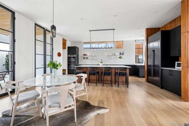 dining space with light wood-type flooring and a wall of windows