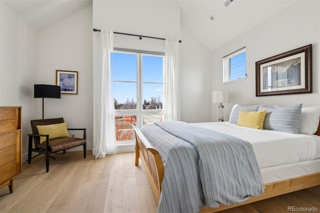 bedroom featuring lofted ceiling and light hardwood / wood-style flooring