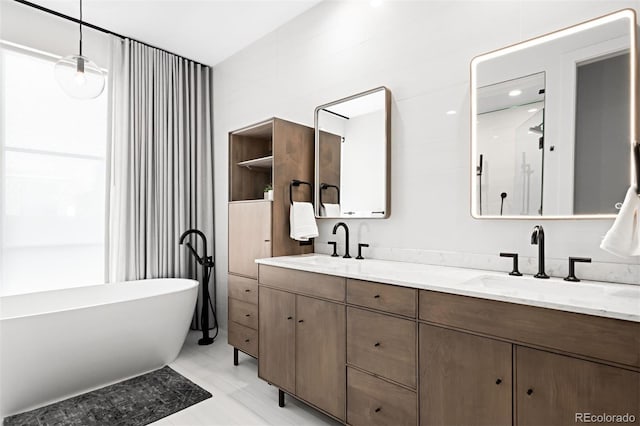 full bathroom featuring double vanity, a soaking tub, and a sink