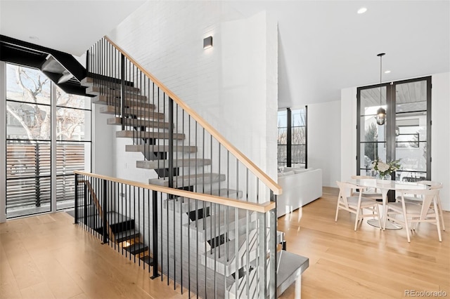 stairway featuring wood finished floors and recessed lighting