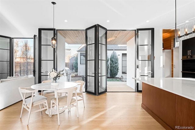 dining room with light wood finished floors, recessed lighting, and floor to ceiling windows