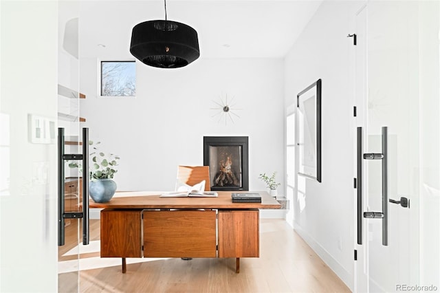 hallway with baseboards and light wood-style floors