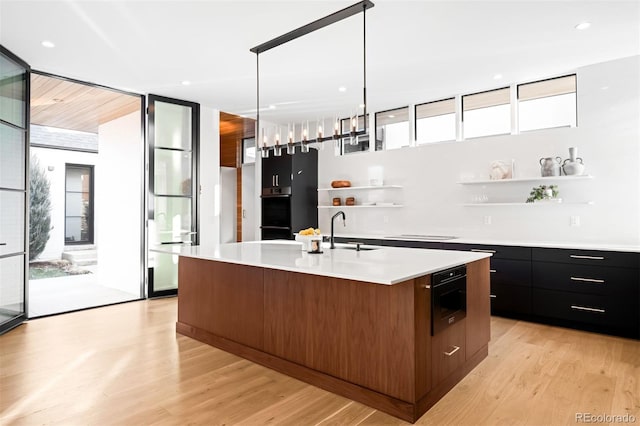 kitchen featuring open shelves, modern cabinets, a sink, and a healthy amount of sunlight