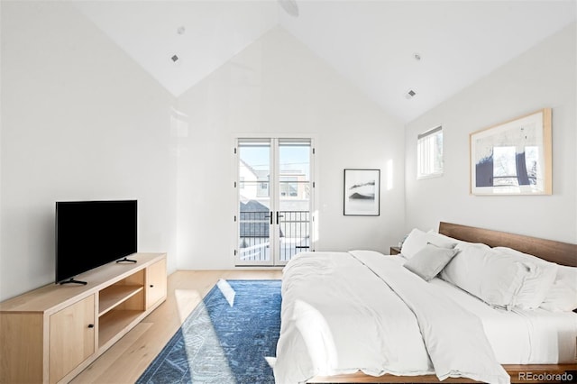 bedroom with access to exterior, multiple windows, high vaulted ceiling, and light wood finished floors