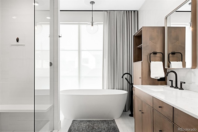 bathroom featuring a freestanding bath, vanity, and walk in shower