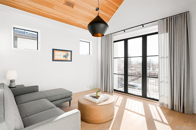 living area with light wood-style floors, lofted ceiling, wooden ceiling, and visible vents