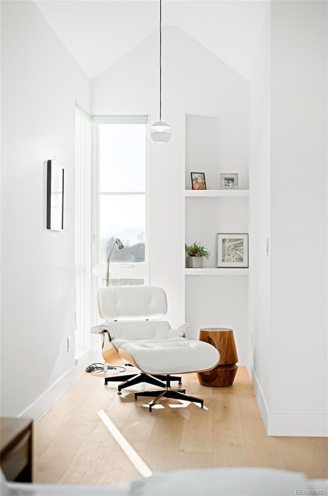 sitting room with baseboards, vaulted ceiling, and wood finished floors