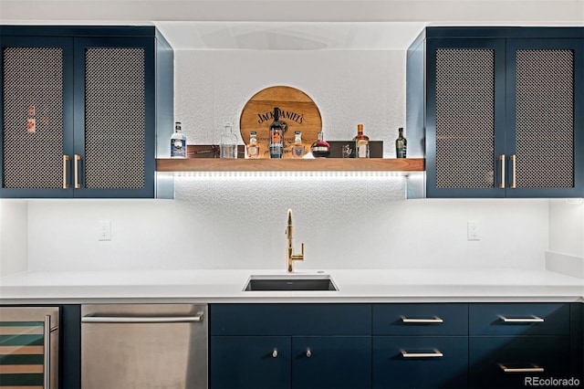 kitchen with blue cabinets, wine cooler, light countertops, and a sink