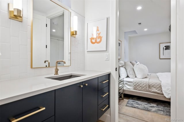 ensuite bathroom featuring ensuite bath, tasteful backsplash, vanity, and recessed lighting