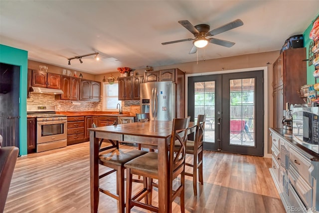 12 Arrawanna St, Colorado Springs, CO 80909 - dining room featuring french doors, light wood-style floors, healthy amount of natural light, and a ceiling fan