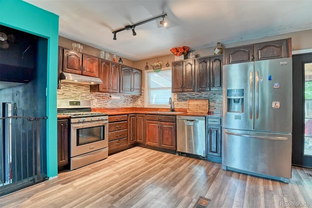12 Arrawanna St, Colorado Springs, CO 80909 - kitchen with appliances with stainless steel finishes, under cabinet range hood, track lighting, a sink, and light wood-style flooring