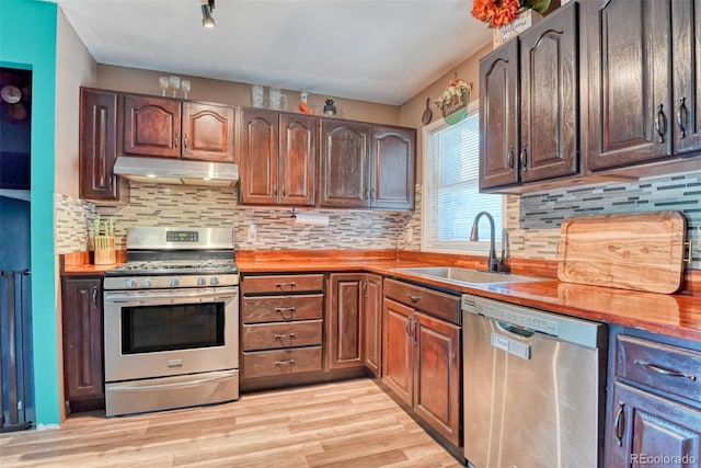12 Arrawanna St, Colorado Springs, CO 80909 - kitchen featuring stainless steel appliances, under cabinet range hood, a sink, and light wood-type flooring