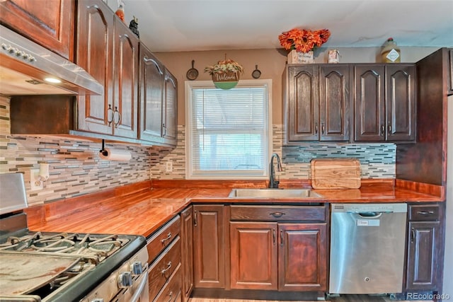 12 Arrawanna St, Colorado Springs, CO 80909 - kitchen with appliances with stainless steel finishes, under cabinet range hood, a sink, and decorative backsplash
