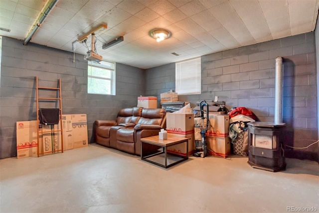 12 Arrawanna St, Colorado Springs, CO 80909 - home theater with finished concrete floors, a wood stove, and concrete block wall