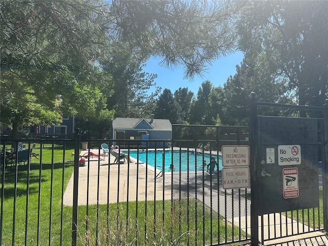 view of pool with a patio and a lawn