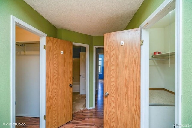 hall with dark hardwood / wood-style floors and a textured ceiling