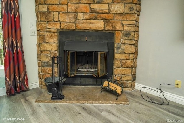 room details featuring hardwood / wood-style flooring and a stone fireplace