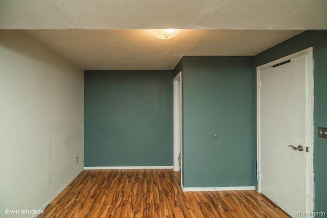 unfurnished room featuring hardwood / wood-style floors and a textured ceiling