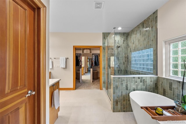 1999 Champions Cir, Castle Rock, CO 80104 - full bathroom with a shower stall, vanity, a freestanding bath, a walk in closet, and tile patterned floors