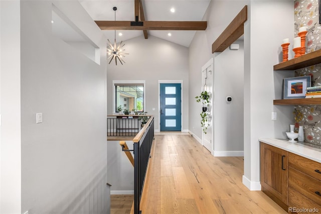 foyer entrance with beam ceiling, high vaulted ceiling, and light wood-type flooring