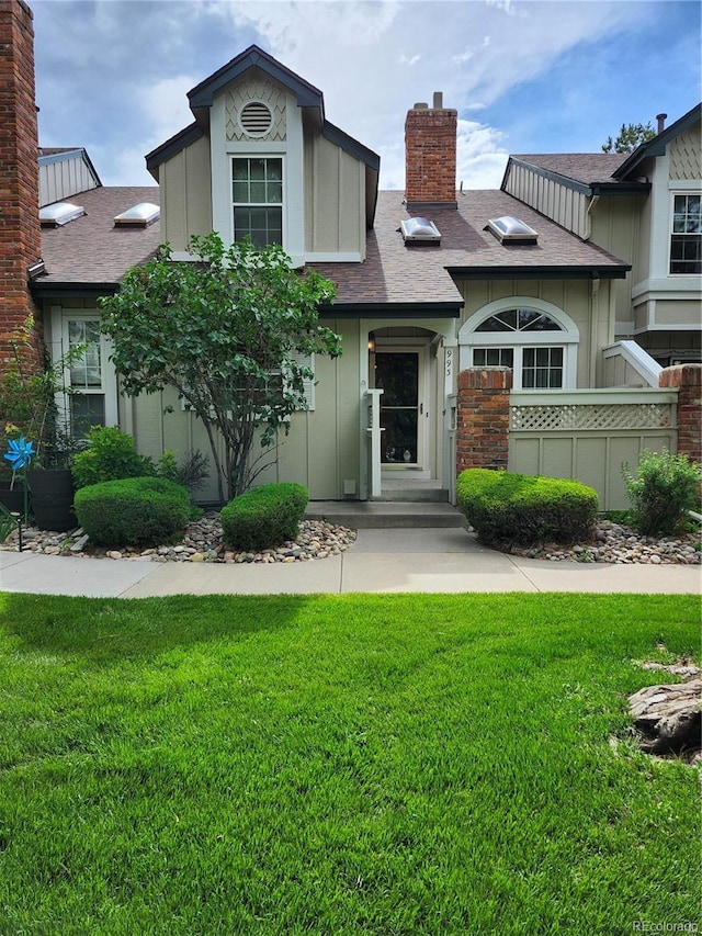 view of front of home with a chimney and a front lawn