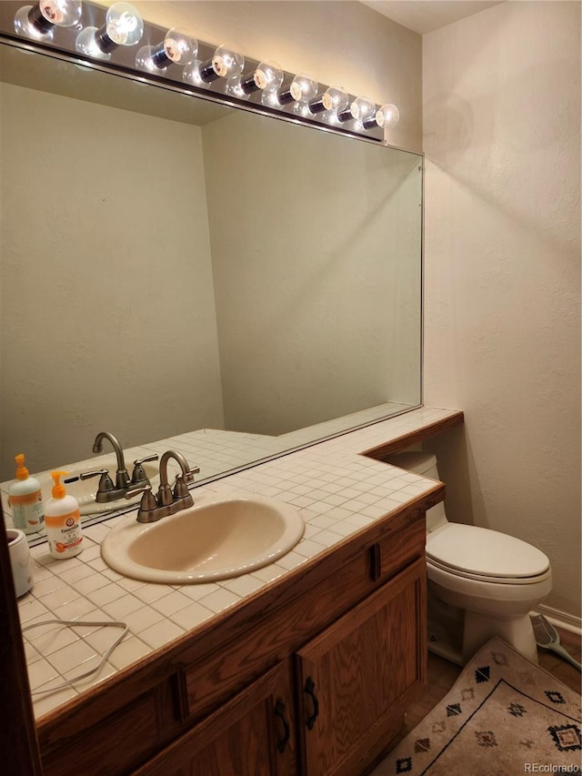 half bathroom with vanity and toilet
