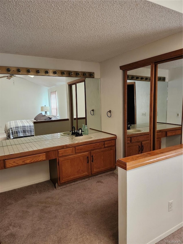 bathroom featuring vanity, a textured ceiling, and carpet flooring