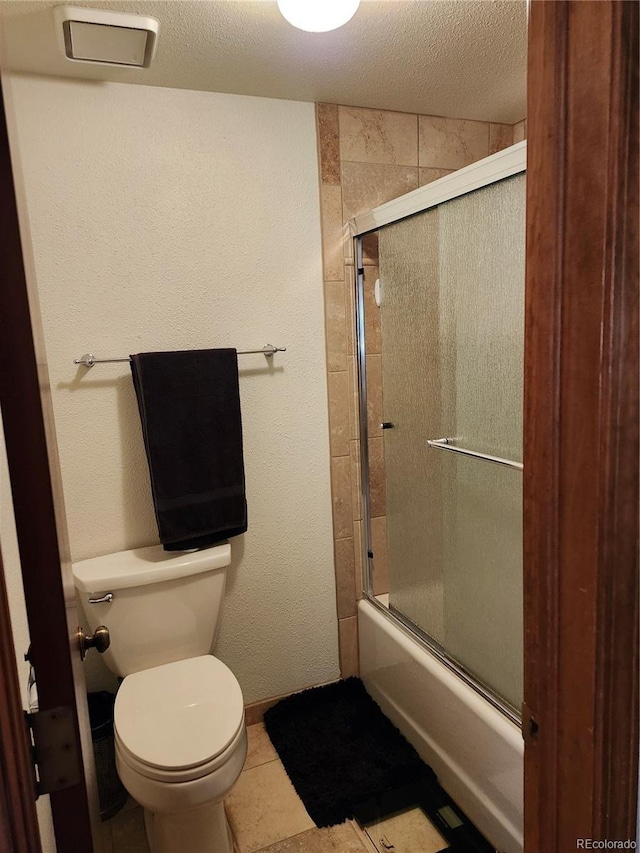 full bathroom featuring enclosed tub / shower combo, a textured ceiling, and tile patterned flooring