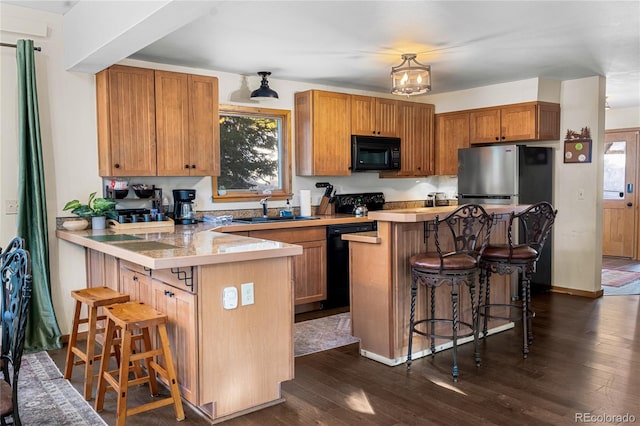 609 Brook Dr, Idaho Springs, CO 80452 - kitchen with black appliances, a kitchen breakfast bar, light countertops, a sink, and a peninsula