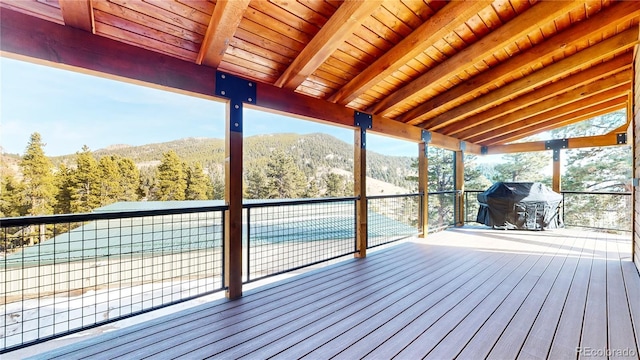 deck with a forest view, a mountain view, and area for grilling