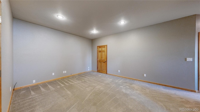 unfurnished room with recessed lighting, baseboards, and light colored carpet