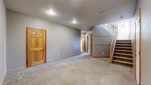 interior space with baseboards, stairway, a textured ceiling, and recessed lighting