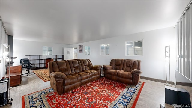 living area with baseboards and wood finished floors