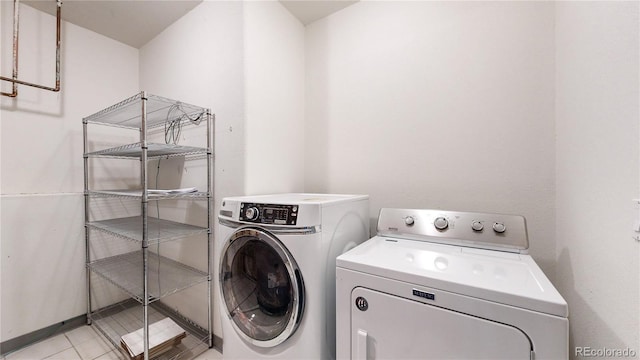 clothes washing area featuring laundry area, light tile patterned floors, and separate washer and dryer