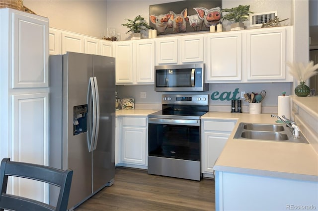 4875 S Balsam Way Unit 6-202, Littleton, CO 80123 - kitchen featuring appliances with stainless steel finishes, white cabinets, light countertops, and dark wood-style floors
