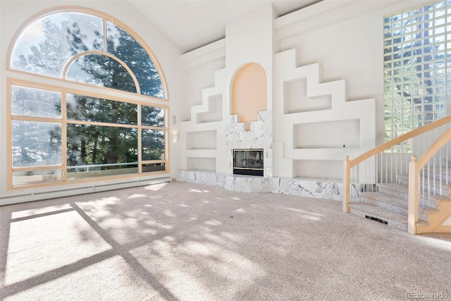 23655 Currant Dr, Golden, CO 80401 - unfurnished living room with carpet floors, baseboard heating, healthy amount of natural light, stairs, and high vaulted ceiling