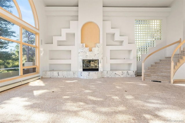 23655 Currant Dr, Golden, CO 80401 - unfurnished living room with carpet flooring, stairs, healthy amount of natural light, built in shelves, and a towering ceiling