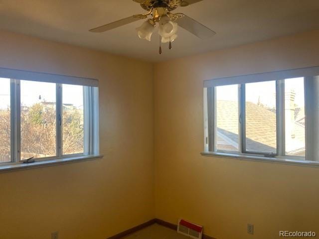 spare room featuring a wealth of natural light and ceiling fan