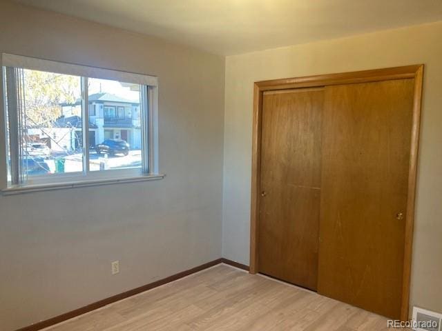 unfurnished bedroom with light hardwood / wood-style floors and a closet