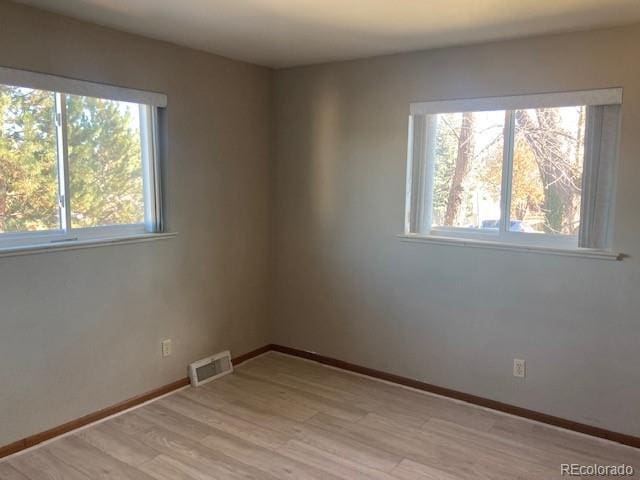 unfurnished room with light wood-type flooring