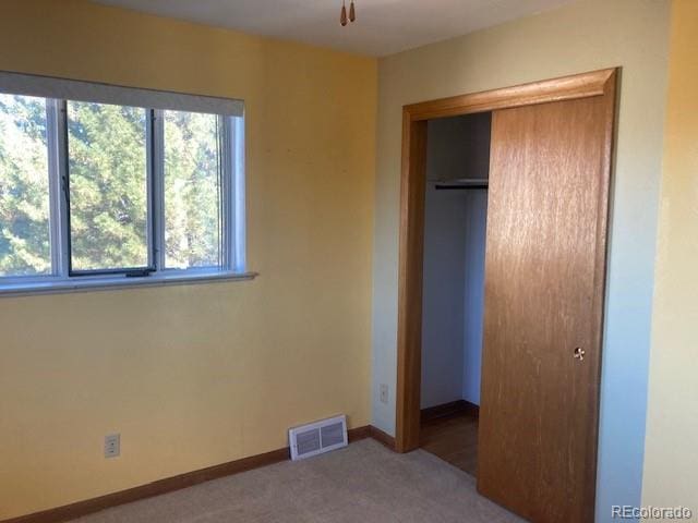 unfurnished bedroom with carpet flooring and a closet