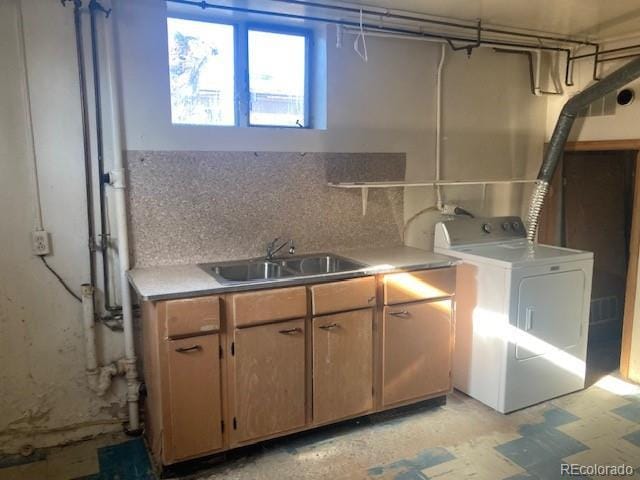 clothes washing area with cabinets, sink, and washer / clothes dryer