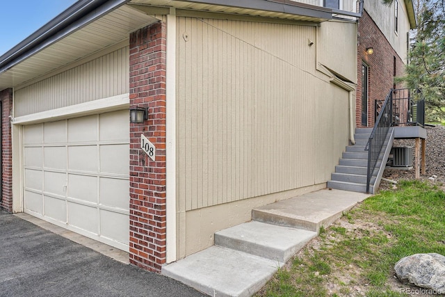 108 S Holman Way, Golden, CO 80401 - view of side of property featuring brick siding, a garage, and stairs